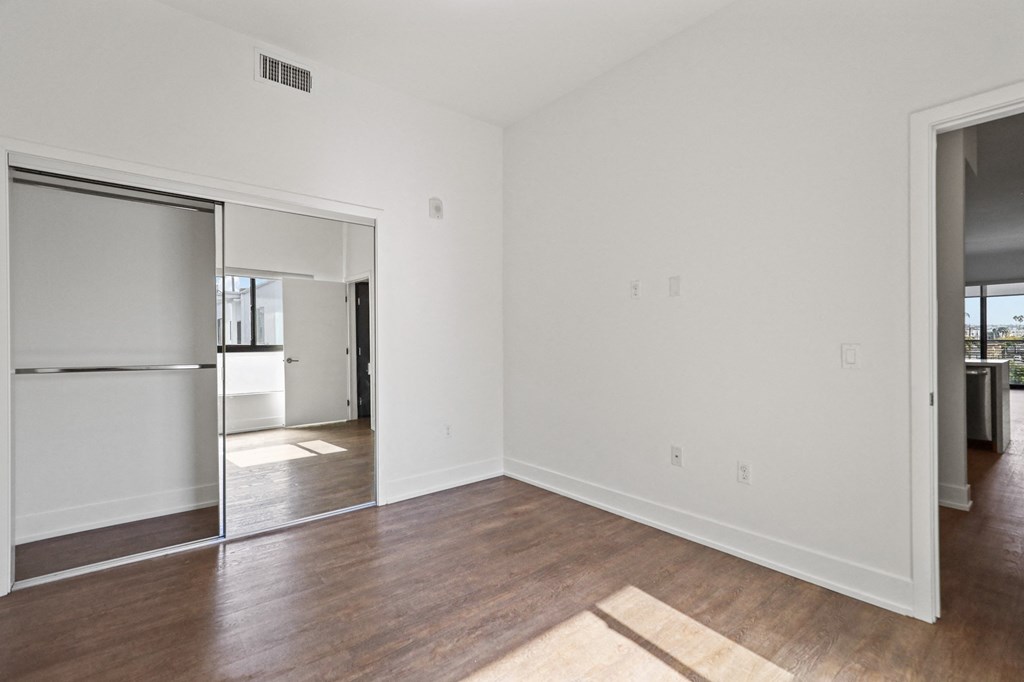 Bedroom with Mirrored Closet and Vinyl Flooring