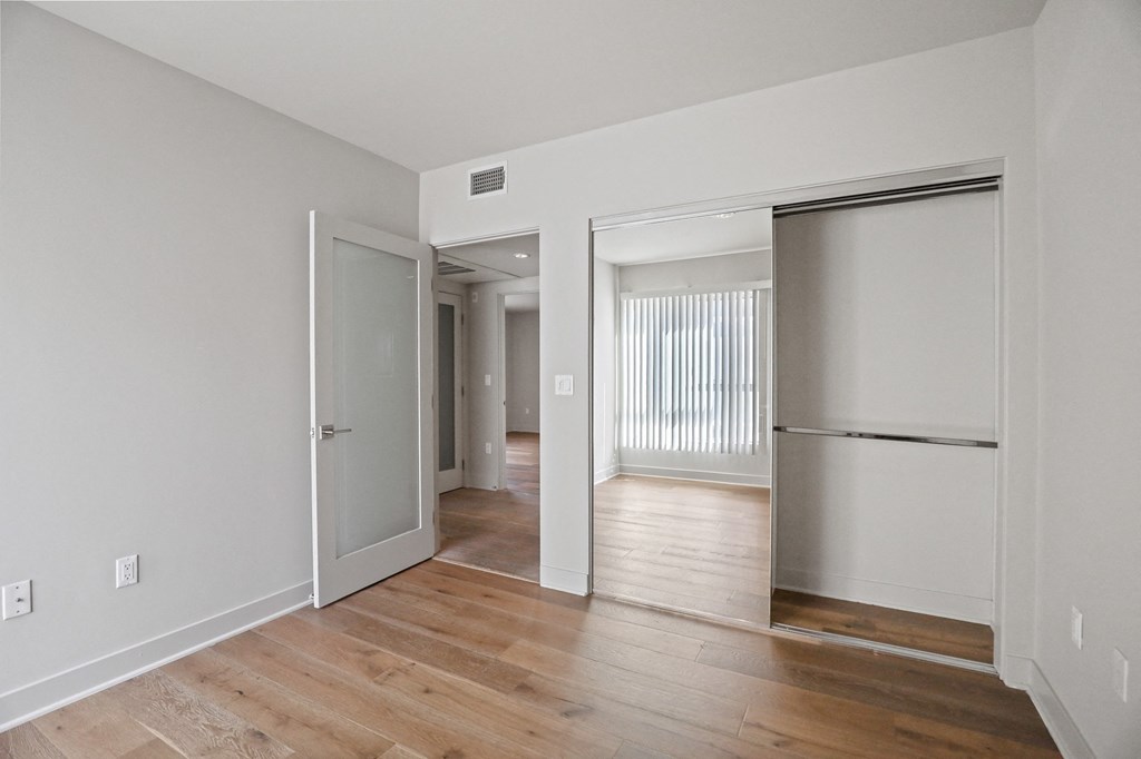 Bedroom with Mirrored Closet and Vinyl Flooring