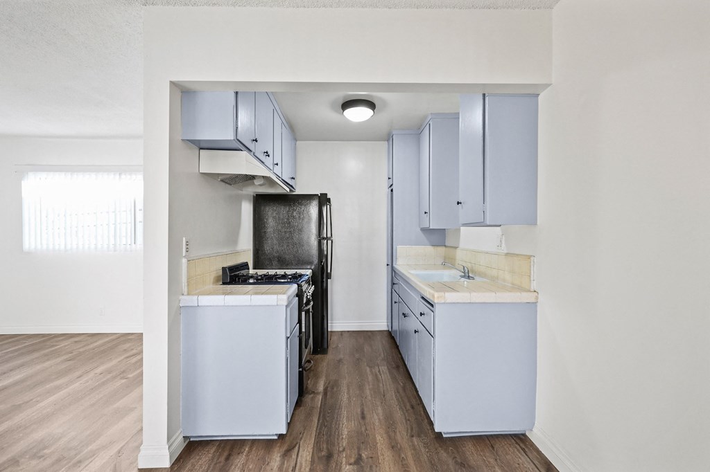 Kitchen with Refrigerator, Stove, and Vinyl Flooring *remodel in select units