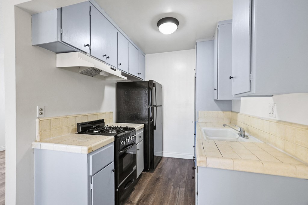 Kitchen with Refrigerator, Stove, and Vinyl Flooring *remodel in select units