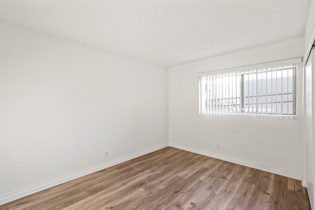 Bedroom with Closet, Windows, and Vinyl Flooring
