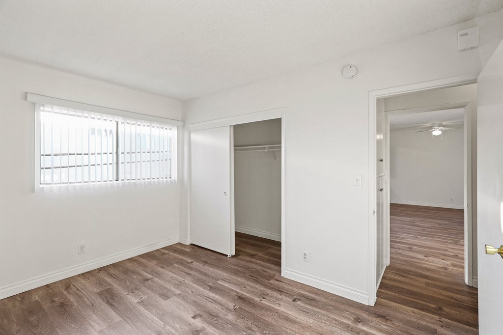 Bedroom with Closet, Windows, and Vinyl Flooring