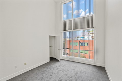 Spacious Bedroom with High Ceilings and Window Views