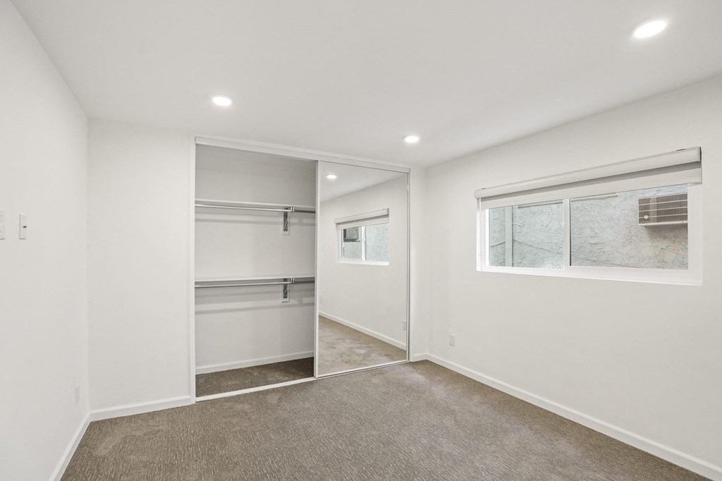 Bedroom with Mirrored Closet, Recessed Lighting, and Large Window