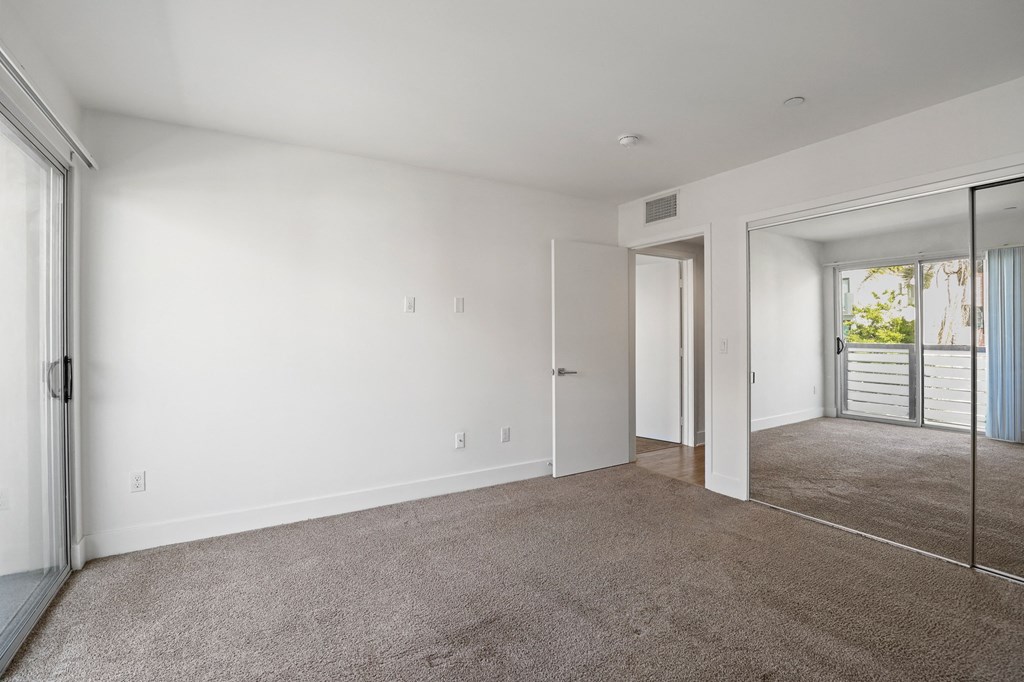 Bedroom with Mirrored Closet and Patio Access