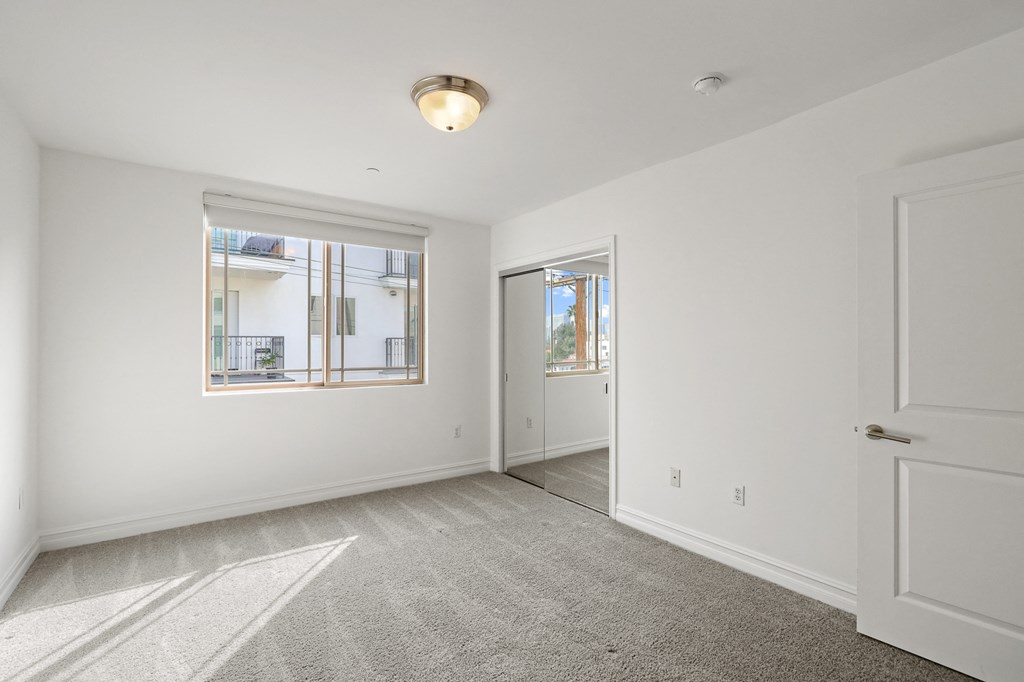 Bedroom with Window and Mirrored Closet