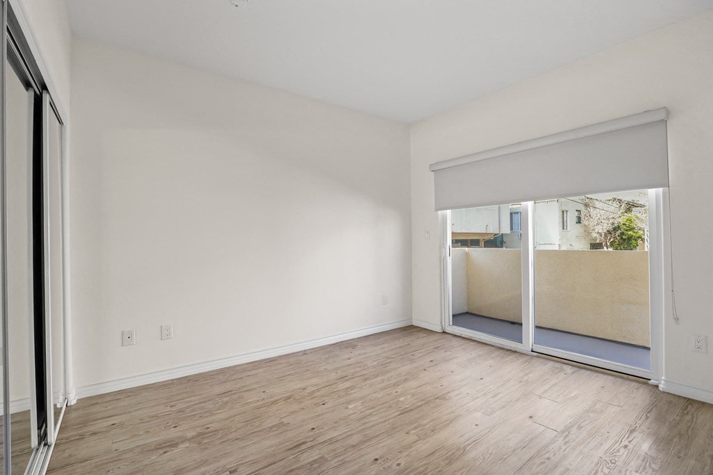 Spacious Bedroom with Mirrored Closet and Private Balcony