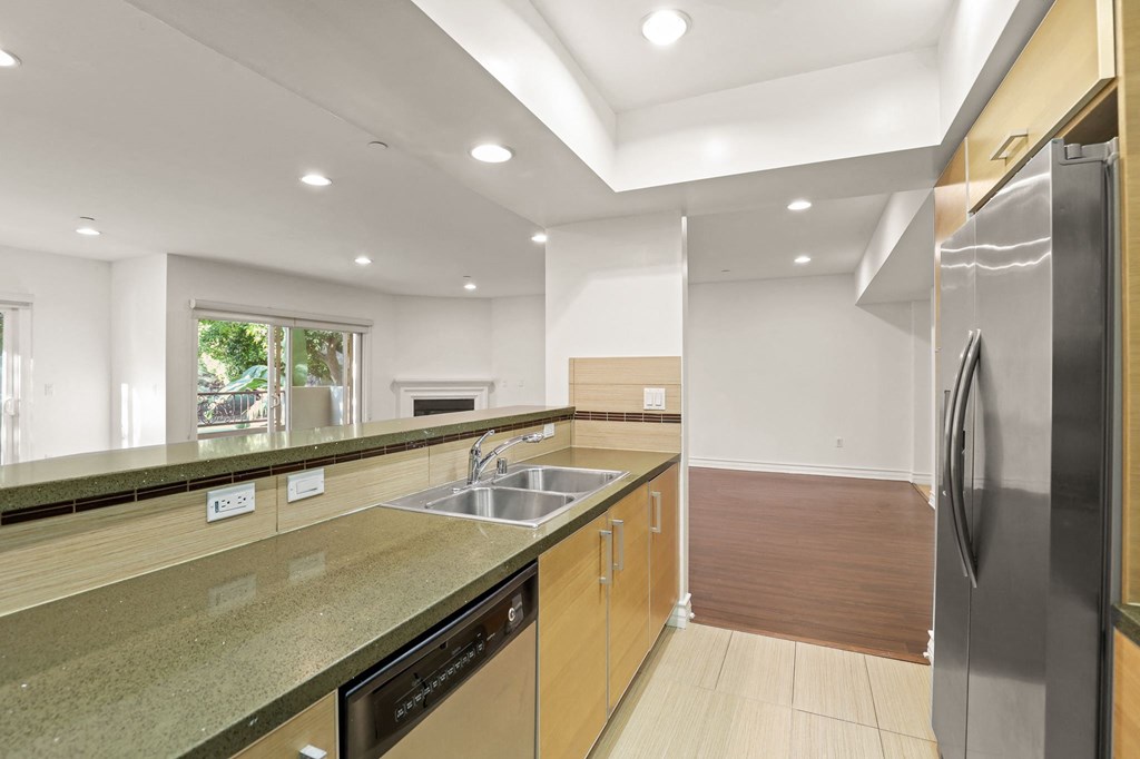 Open-Concept Kitchen and Living Room Area with Electric Fireplace and Patio