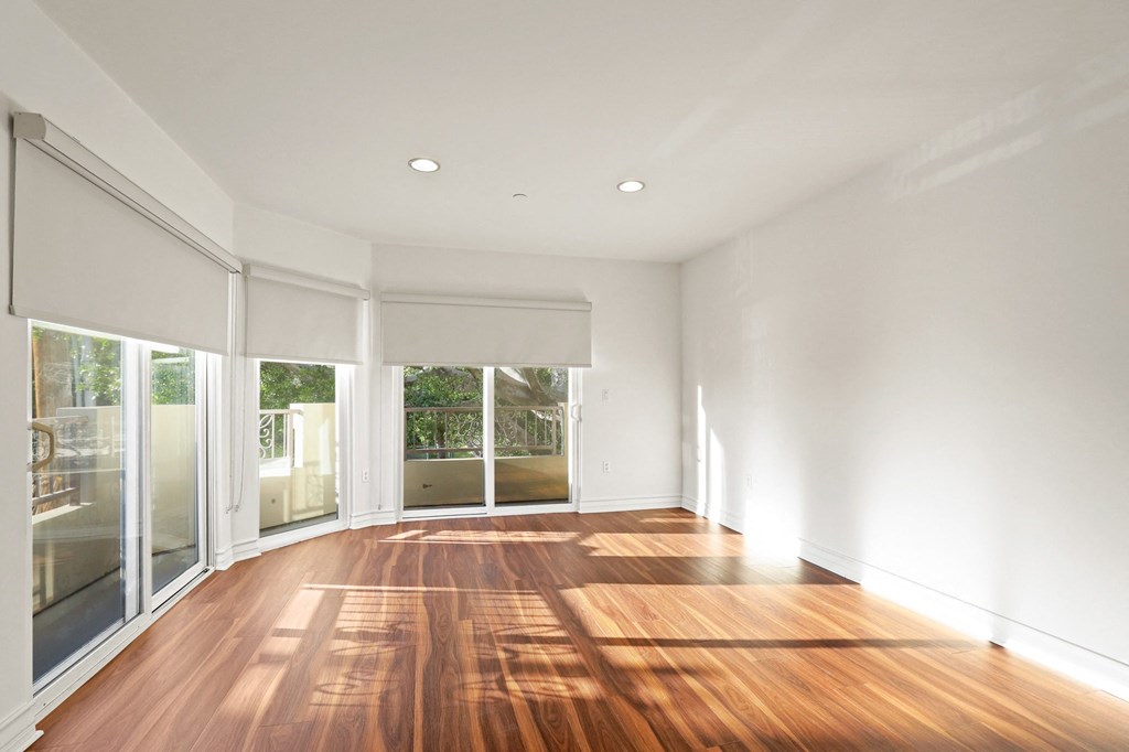 Large Bright Living Room Space with Balcony, Custom Shades, and Lots of Windows Providing Natural Light