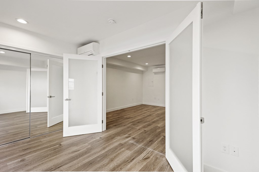 Bedroom with Double Doors and Vinyl Wood Flooring