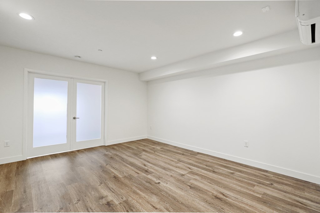 Large Bedroom with Double Doors, Recess Lighting, and Vinyl Wood Flooring
