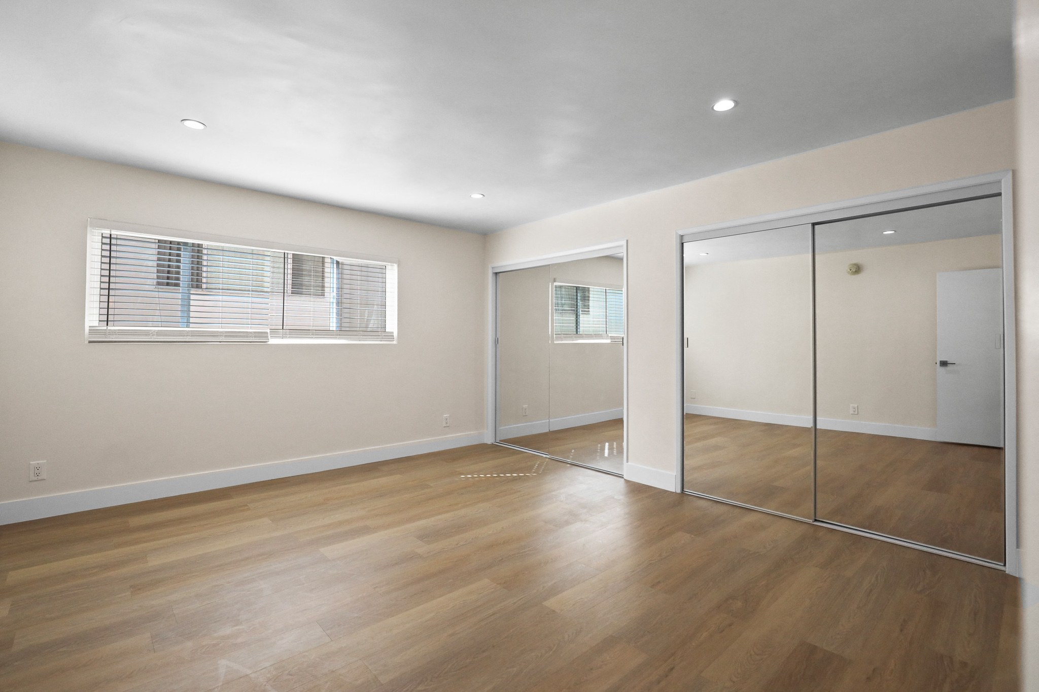 Large Bedroom with Double Mirrored Closets and Vinyl Flooring