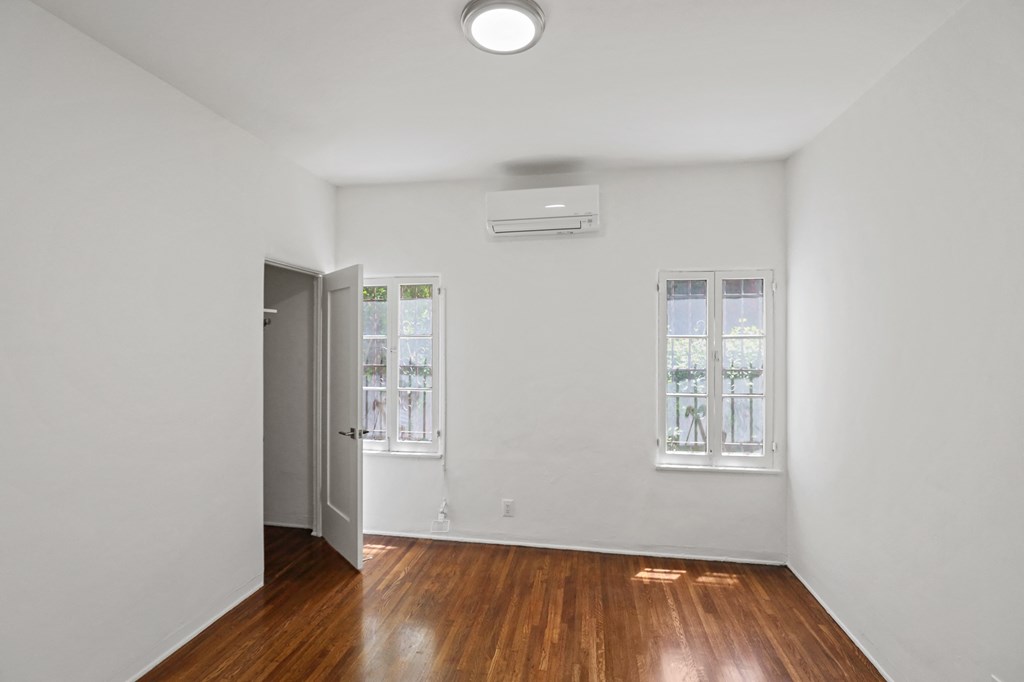 Bedroom with Hardwood Flooring and a Walk-In Closet