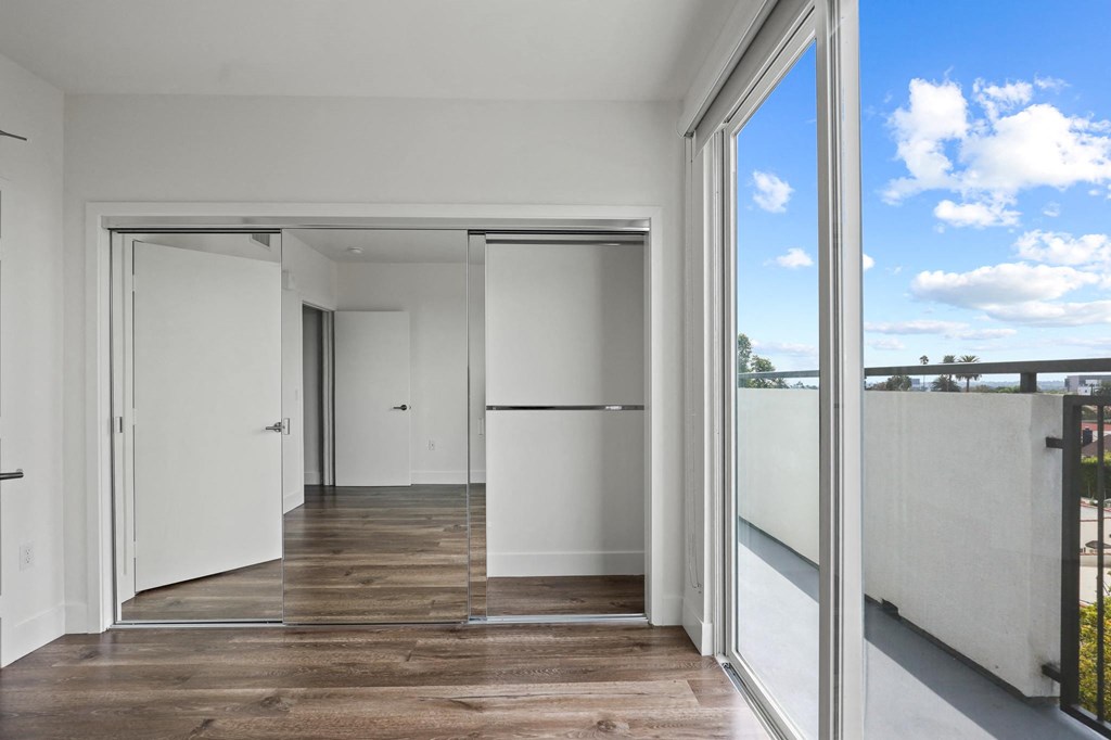 Bedroom with Mirrored Closet, Vinyl flooring, and Balcony with Skyline Views