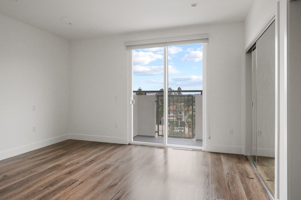 Bedroom with Mirrored Closet, Recessed Lighting, Vinyl Flooring, and Patio