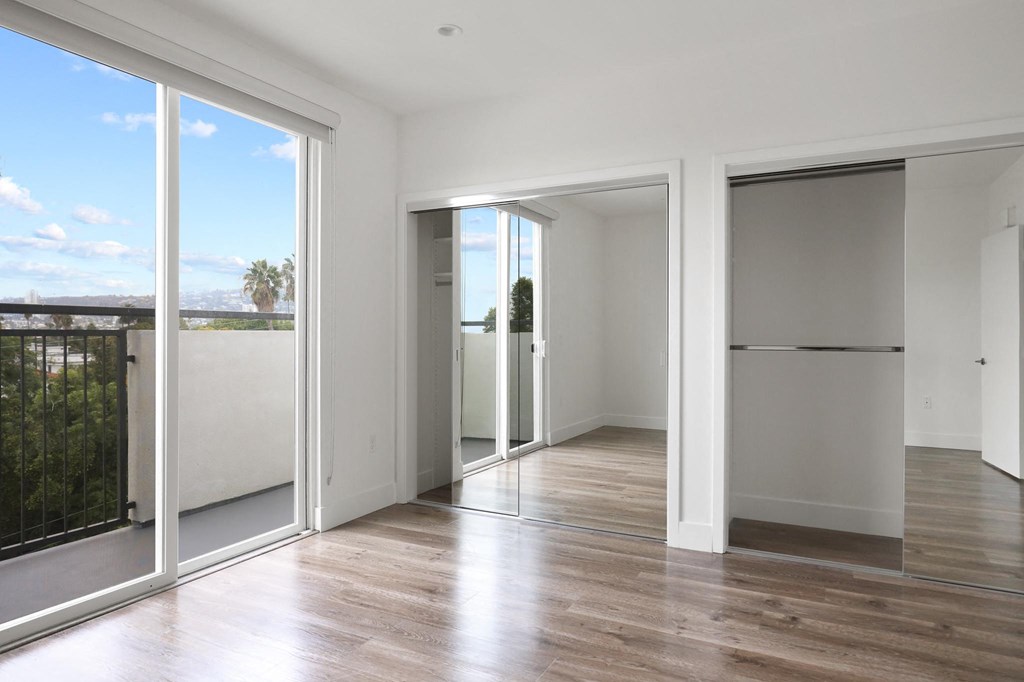 Bedroom with Double Mirrored Closet, Vinyl Flooring, and Balcony