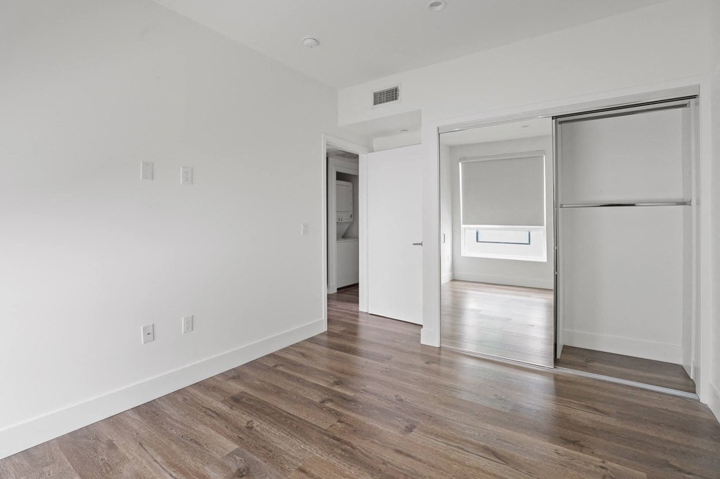 Bedroom with Mirrored Closet and Vinyl Flooring
