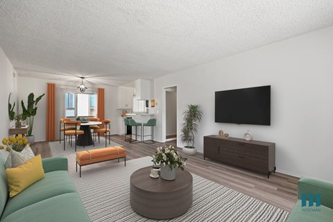 A living room with a green sofa, a wooden coffee table, and a flat-screen TV mounted on the wall.