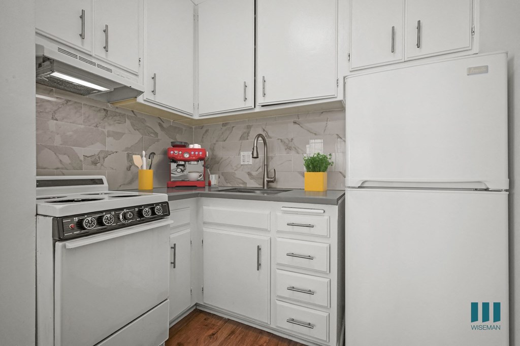 A kitchen with white appliances and cabinets.