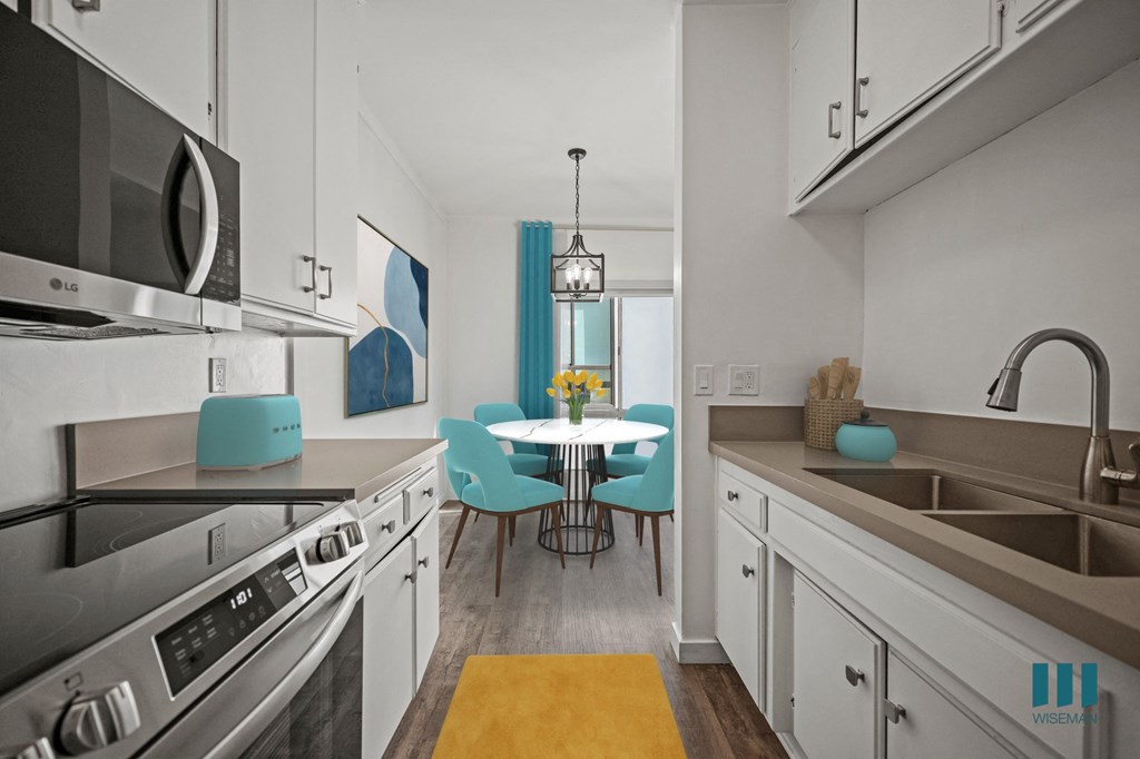 A kitchen with a table and chairs in the middle.