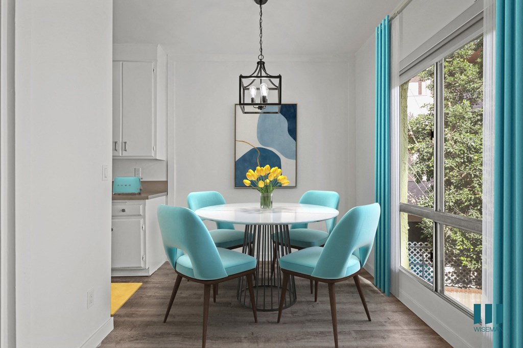 A dining room with a white table and blue chairs.