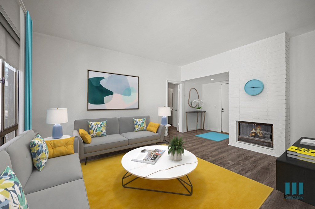 A living room with a grey couch, a white coffee table, and a yellow rug.