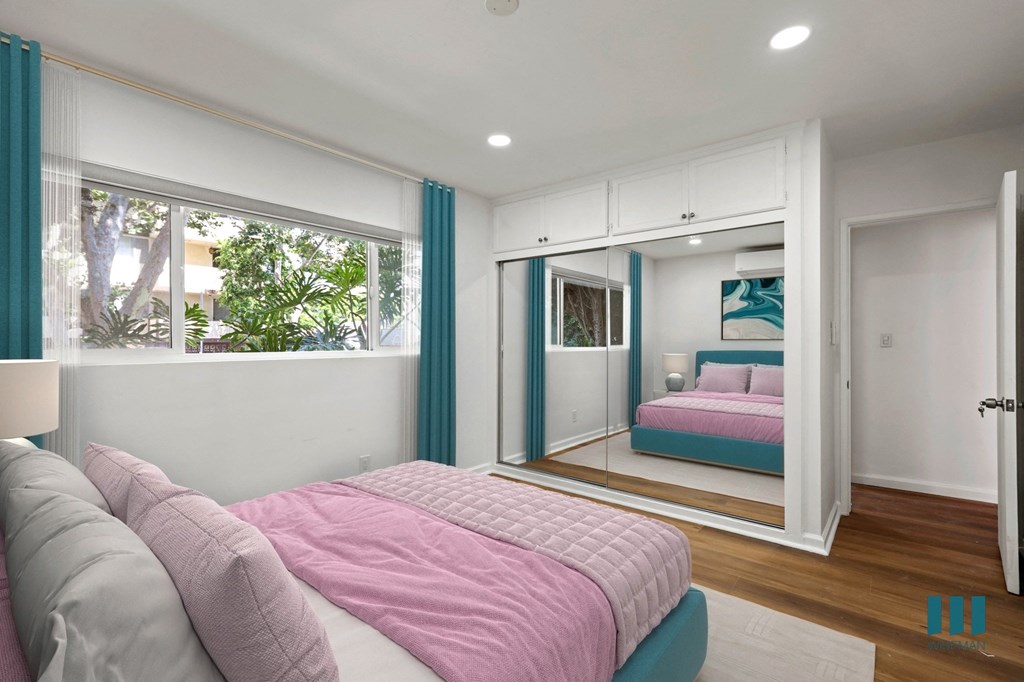 Bedroom with Vinyl Flooring and Mirrored Closet with Overhead Storage