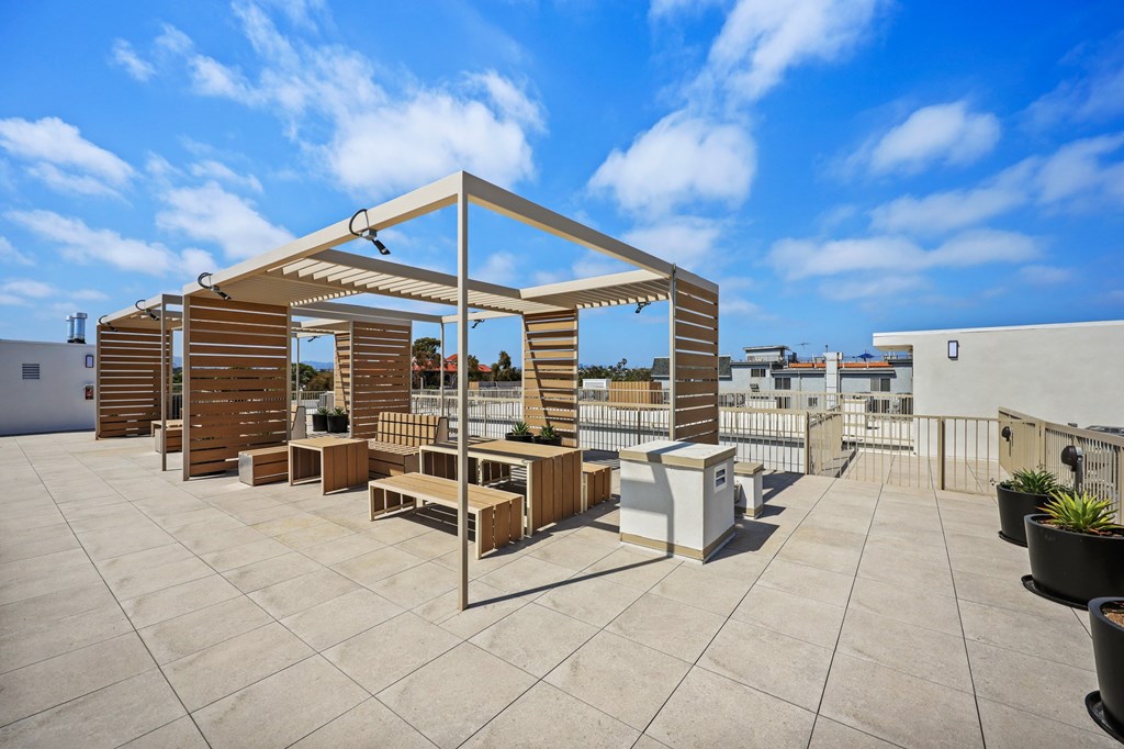 A patio with a table and chairs under a pergola.