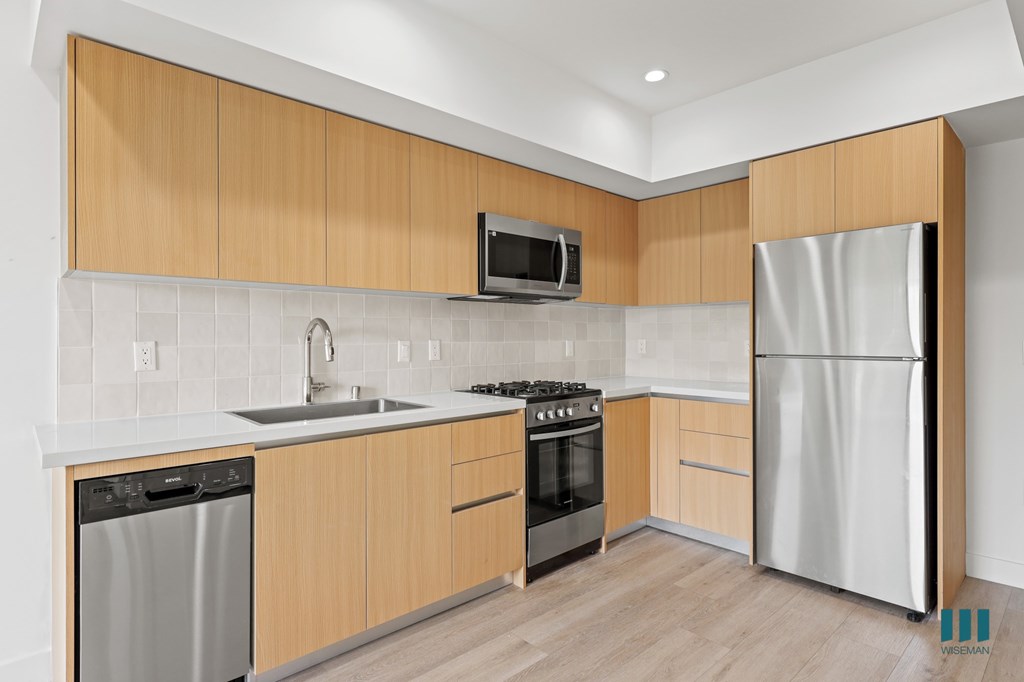 A modern kitchen with wooden cabinets and stainless steel appliances.