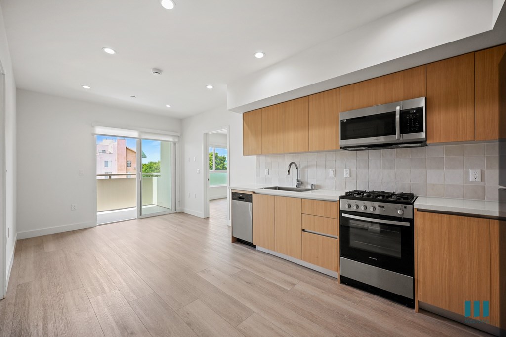 A modern kitchen with wooden cabinets and a stainless steel oven.