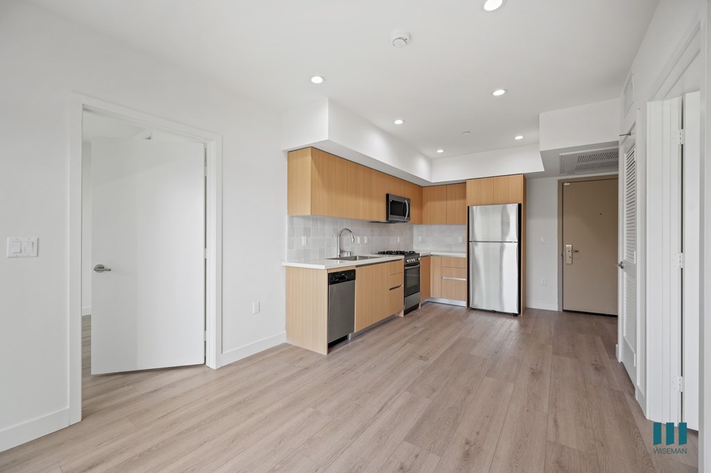 A kitchen with wooden floors and white walls.