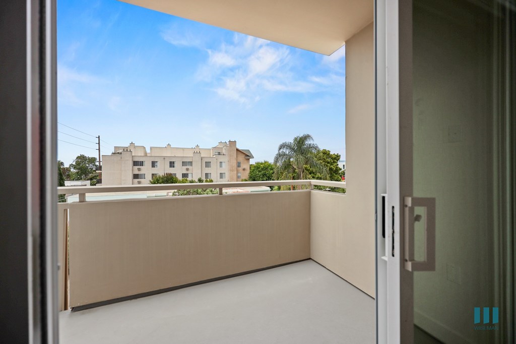 A balcony with a view of a building and trees.