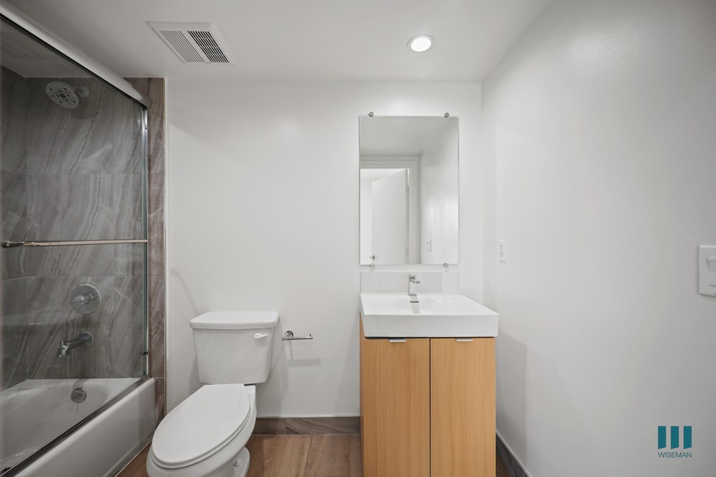 A white toilet sits next to a sink in a small bathroom.