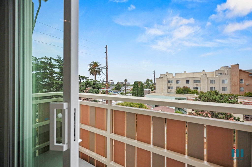 A view from a window looking out at a building and trees.