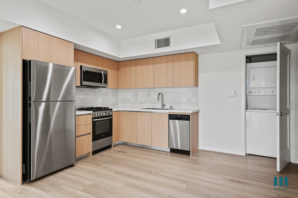 A modern kitchen with wooden cabinets and stainless steel appliances.