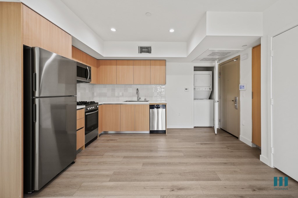 A modern kitchen with wooden cabinets and stainless steel appliances.