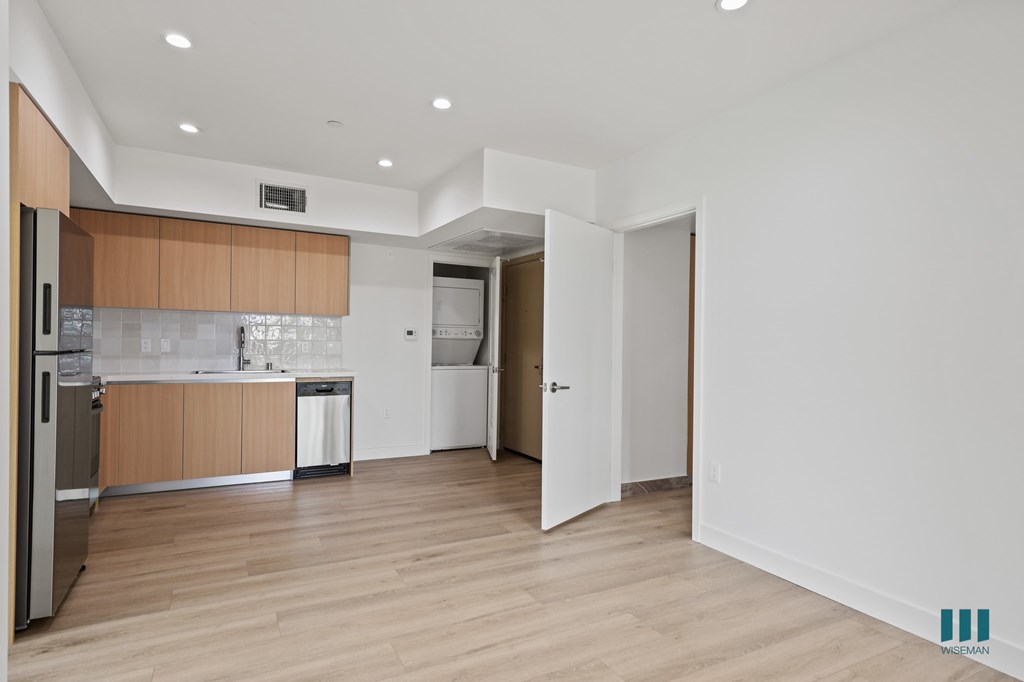 A kitchen with wooden floors and white walls.