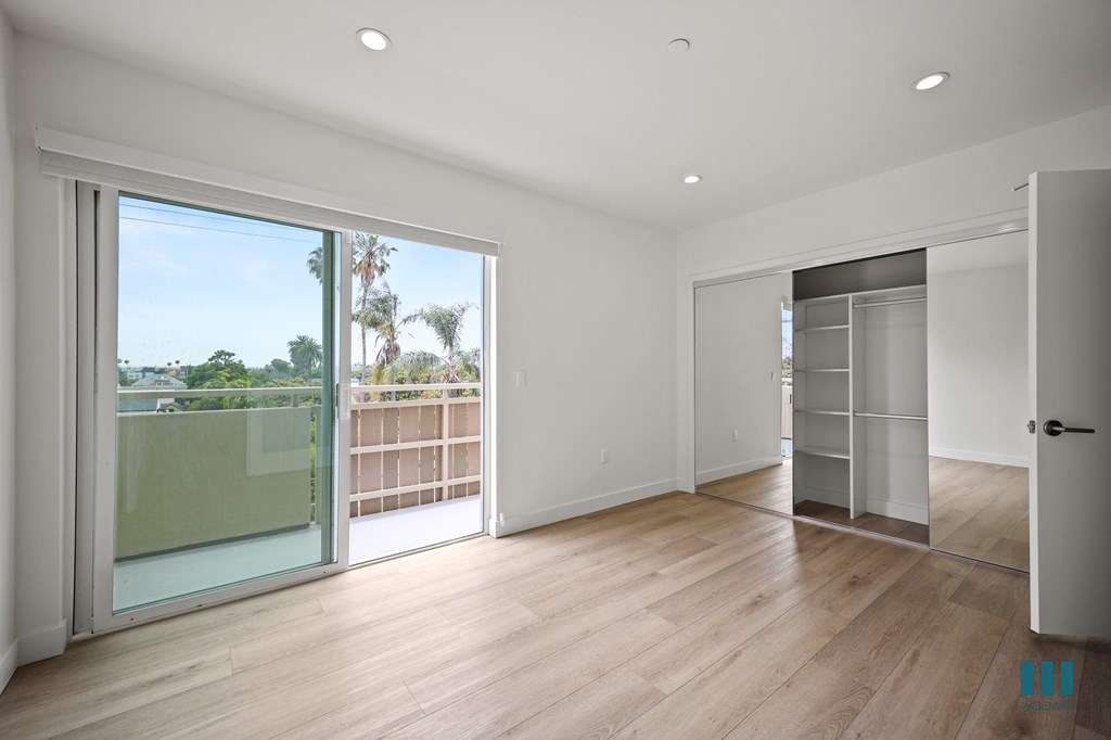 A room with a sliding glass door leading to a balcony.
