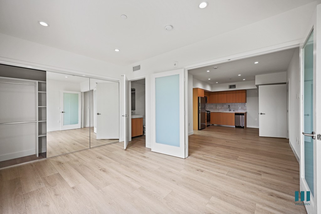 A spacious room with wooden floors and white walls.