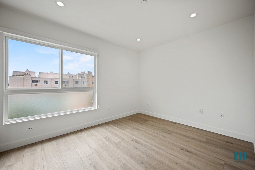 Empty room with a window overlooking a cityscape.
