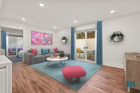 A living room with a grey couch, a pink ottoman, a coffee table, and a painting on the wall.