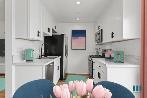 A kitchen with white cabinets and a black refrigerator.