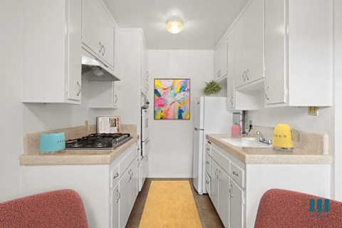 A kitchen with white cabinets and a yellow stove.
