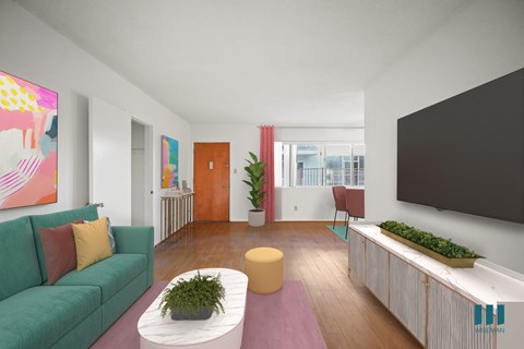 A living room with a green couch, a yellow coffee table, and a large painting on the wall.