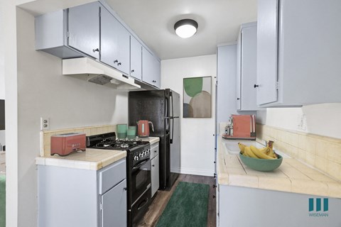 A kitchen with a stove top oven and a refrigerator.