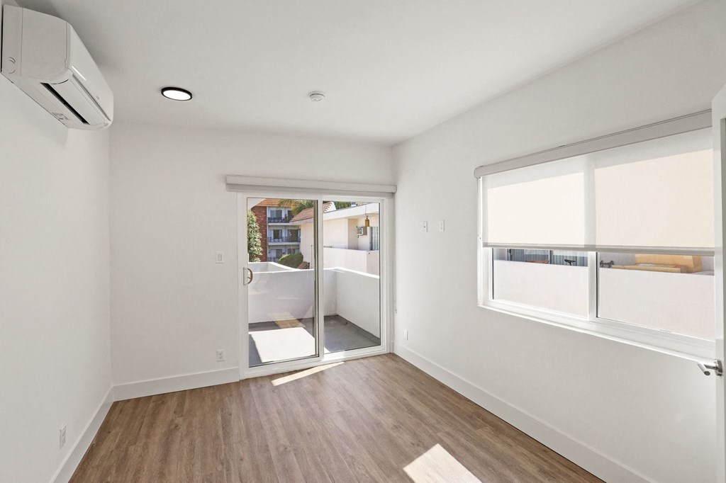 Bedroom with Windows, Vinyl Flooring, and Patio