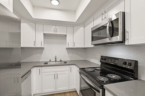 a kitchen with white cabinets and a stove and a microwave