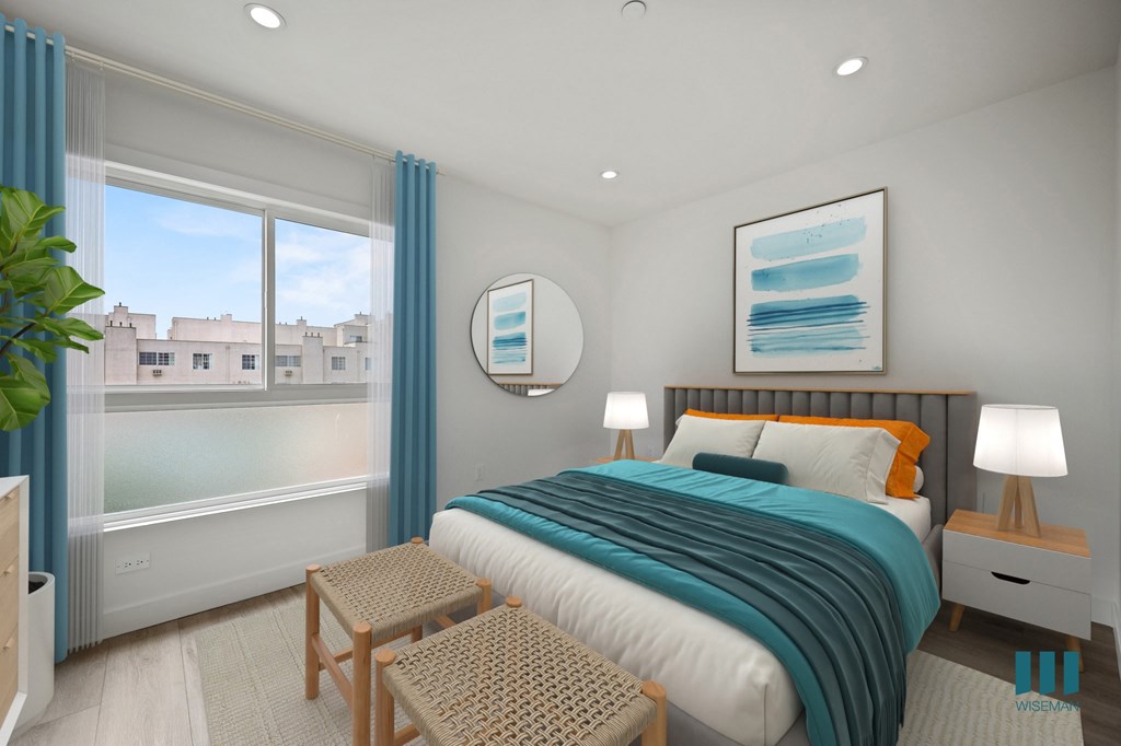 A bedroom with a large bed and a view of buildings outside the window.