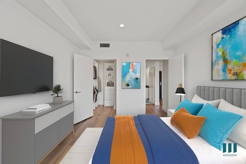 A modern bedroom with a large bed and a painting on the wall.