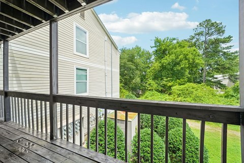 A house with a deck and trees in the background.
